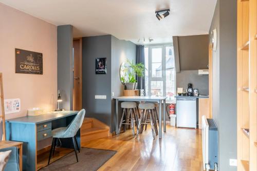 a kitchen and living room with a table and stools at Holiday-Home Maas&Mechelen in Maasmechelen