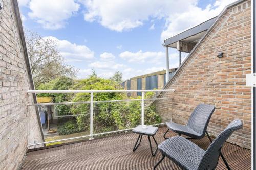 two chairs and a table on a balcony at Holiday-Home Maas&Mechelen in Maasmechelen