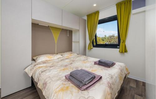 a bedroom with a bed with yellow curtains and a window at Stunning Home In Mandre With Kitchen in Mandre