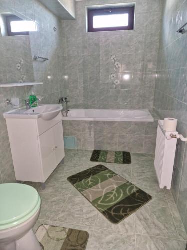 a bathroom with a toilet and a sink and a tub at Splendid Aparthotel in Năvodari