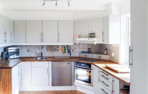 a white kitchen with white cabinets and a sink at 5 Bedroom Amazing Home In Matre in Bauge