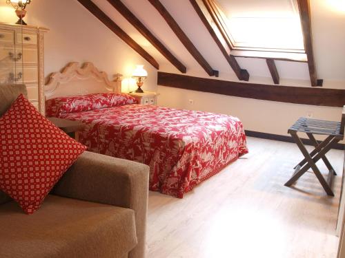 Un dormitorio con una cama y un sofá y una ventana. en Hosteria Sierra del Oso, en Potes