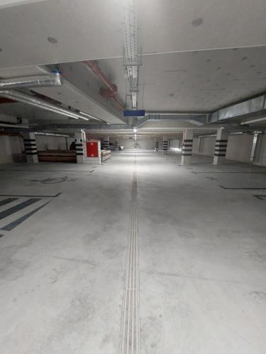 an empty parking garage with a large room with white floors at Apartament Słoneczny Shellter Rogowo in Rogowo