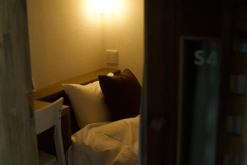 a bedroom with a bed and a light on the wall at HOTEL BOTH in Shari