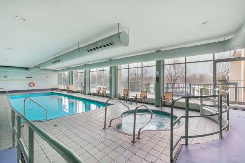 a large swimming pool with tables and chairs in a building at Best Western PLUS Mission City Lodge in Mission City