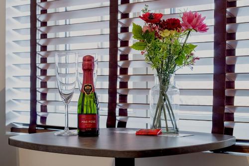 a bottle of wine and a glass and flowers on a table at JT HOMES in Bruges
