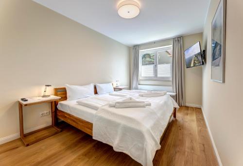 1 dormitorio con 1 cama blanca grande y ventana en Villa Madeleine App. 2 en Heringsdorf