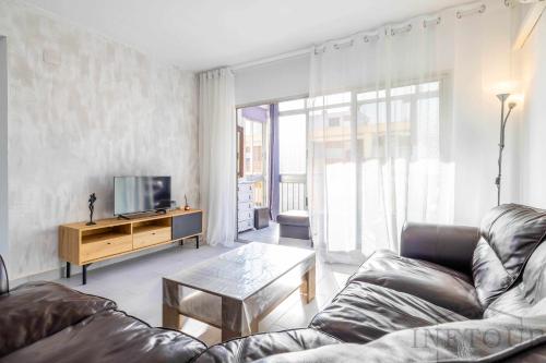 ein Wohnzimmer mit einem Sofa und einem TV in der Unterkunft Inftour Primavera Apartamento in Calpe