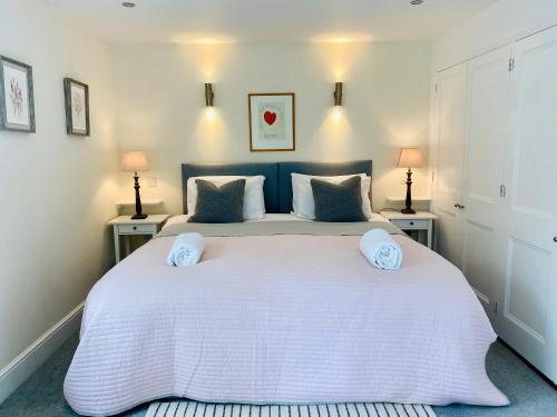 ein Schlafzimmer mit einem großen weißen Bett mit zwei Tischen in der Unterkunft The Applery, Leyburn Yorkshire Dales National Park in Leyburn