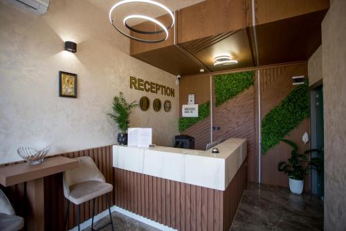 a reception area with a green wall in a room at Hotel CITY Sandanski in Sandanski
