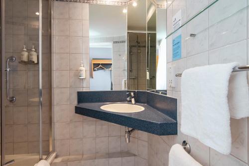 a bathroom with a sink and a shower at Holiday Inn Express Newport, an IHG Hotel in Newport