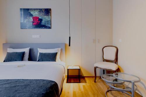 a bedroom with a bed and a chair at JT HOMES in Bruges