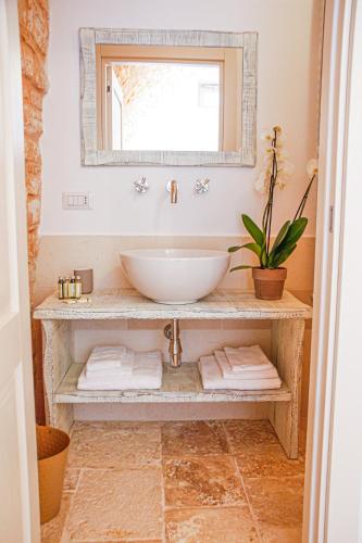 a bathroom with a bowl sink and a mirror at AGROSILENTE in Locorotondo