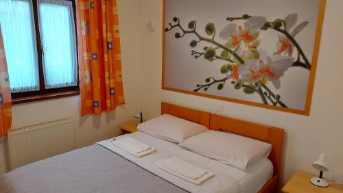 a bedroom with a bed with a painting on the wall at house anna in Rastovača