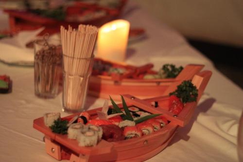a table with a tray of food and a candle at Mercure Cayenne Royal Amazonia in Cayenne