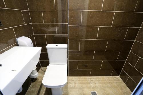 a bathroom with a white toilet and a sink at Hotel CITY Sandanski in Sandanski