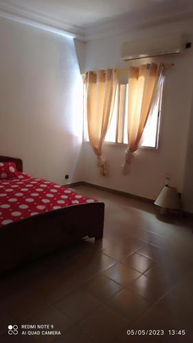 1 dormitorio con 1 cama y 2 ventanas en Villa meublée à Sendou, en Siendou