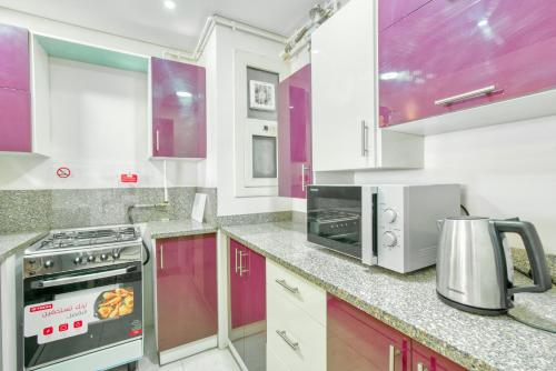 a kitchen with purple cabinets and a stove top oven at LOFTS by Elegant Hospitality in Cairo
