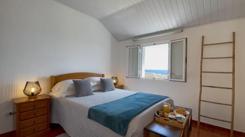 um quarto com uma cama e uma janela em Blue by the Sea House em Paul do Mar