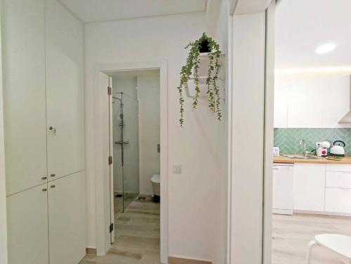 a kitchen with white cabinets and a wreath on the wall at Lovely Terrace Apart. Downtown in Faro