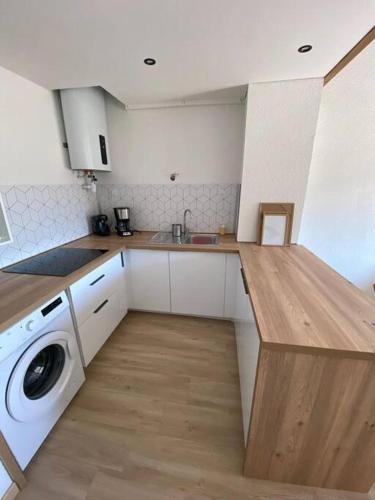 une cuisine avec un évier et une machine à laver dans l'établissement Grand studio entre le golf et la plage à 800m, à Saint Cyprien Plage