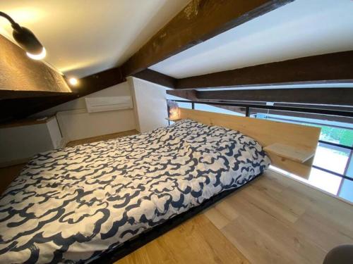 a large bed in a room with a window at Grand studio entre le golf et la plage à 800m in Saint-Cyprien-Plage