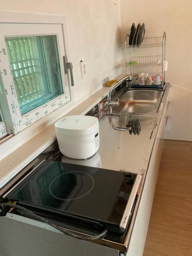 a kitchen with a sink and a stove top at Guesthouse Comfort Place in Buan