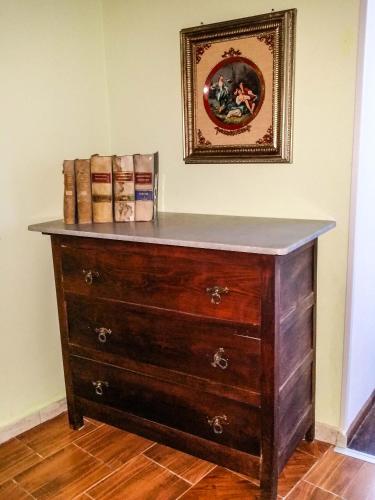 a wooden dresser in a room with a picture on the wall at La Dimora Antica in Viggianello