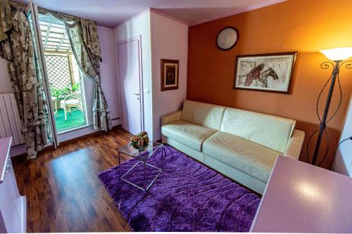 a living room with a couch and a clock on the wall at La Dimora Antica in Viggianello
