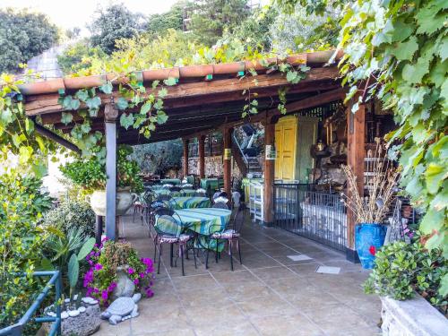 a patio with tables and chairs under a pergola at La Dimora Antica in Viggianello