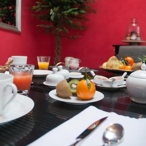 une table avec des plaques de nourriture et des oranges sur celle-ci dans l'établissement Maison l'épicurienne, à Les Sables-dʼOlonne