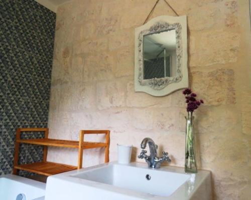 baño con lavabo y espejo en la pared en trullo fino, en Cisternino