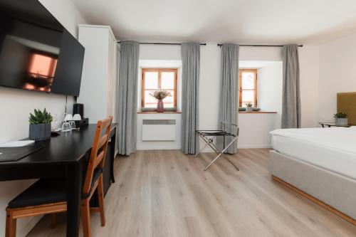 a bedroom with a desk and a bed in a room at Penzion Austis in Znojmo