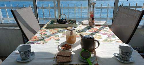 a table with a table cloth on a table with a view of the ocean at SUNSET ROOM AT FRONT BEACH - HABITACION EN LA PLAYA en Piso compartido in Tavernes de Valldigna
