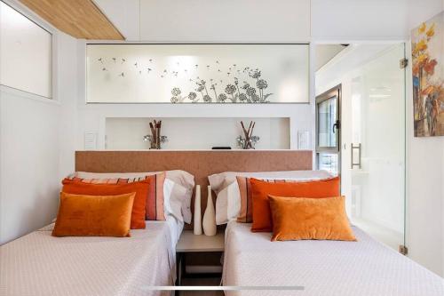 Duas camas com almofadas laranja num quarto em II-II Hub Luxury New Apartments em Barcelona