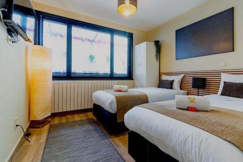 a hotel room with two beds and a laptop on a table at JT HOMES in Bruges
