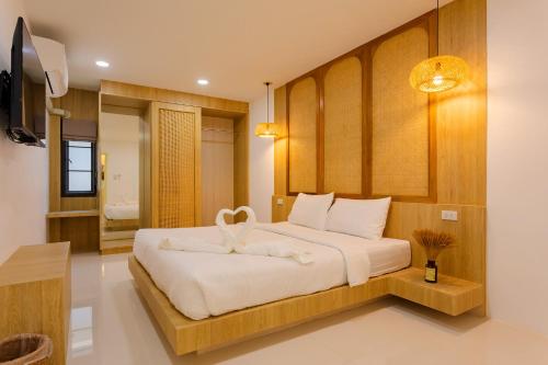 a bedroom with a large bed with white sheets at Neenlawat Riverside in Suratthani