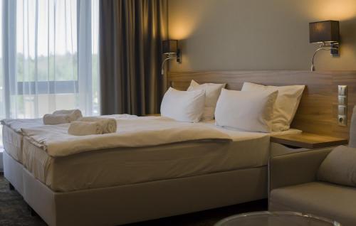 ein Hotelzimmer mit einem großen Bett mit Handtüchern darauf in der Unterkunft Baltic Plaza Hotel Medi Spa in Kołobrzeg