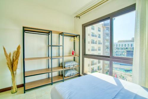 a bedroom with a bed and a large window at LOFTS by Elegant Hospitality in Cairo
