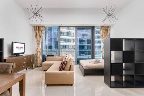 salon z kanapą, łóżkiem i telewizorem w obiekcie Studio with a view in the top location w Dubaju