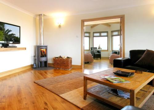 a living room with a table and a fireplace at Kirkbride farm holiday cottages 