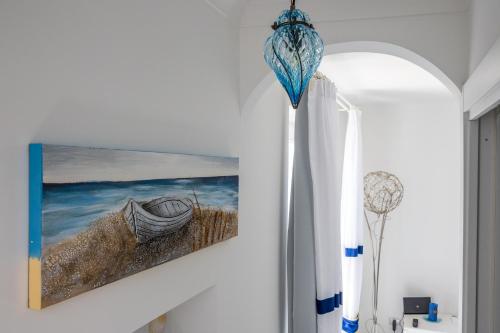 Blue Waves - De Vivo Realty Positano في بوسيتانو: لوحة لقارب معلق على الحائط