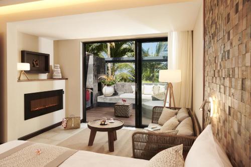 a living room with a couch and a fireplace at Palm Hotel & Spa in Petite Île