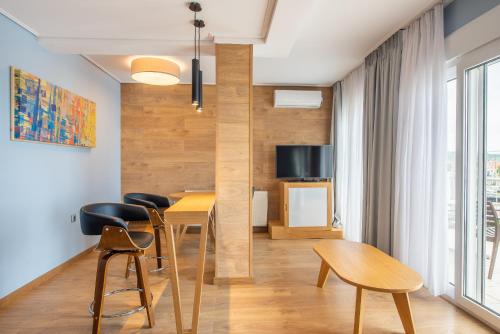 a living room with a table and chairs and a tv at Heliotrope Hotels in Mytilini