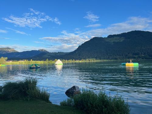 three boats on a lake with mountains in the background at Herzi Chalet - top ausgestattet, neu, chic und sehr gemütlich in Walchsee