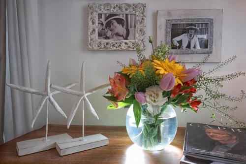 a vase of flowers on a table with two windmills at Affittacamere Capri Dolce Vita in Capri
