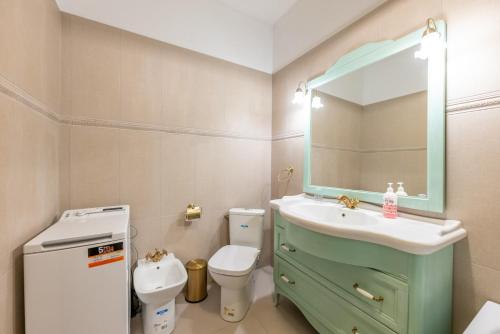 a bathroom with a sink and a toilet and a mirror at CozyFlat in the central Arad in Arad