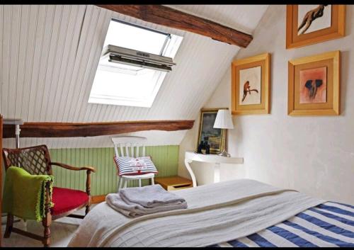 ein Schlafzimmer mit einem Bett und einem Dachfenster in der Unterkunft Nid de Corsaire, Vue Mer & Accès plage in Saint-Malo