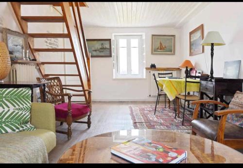 - un salon avec un escalier, une table et des chaises dans l'établissement Nid de Corsaire, Vue Mer & Accès plage, à Saint-Malo