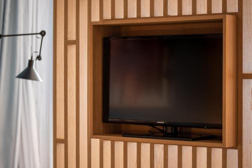 a flat screen tv in a wooden entertainment center at Heliotrope Hotels in Mytilini